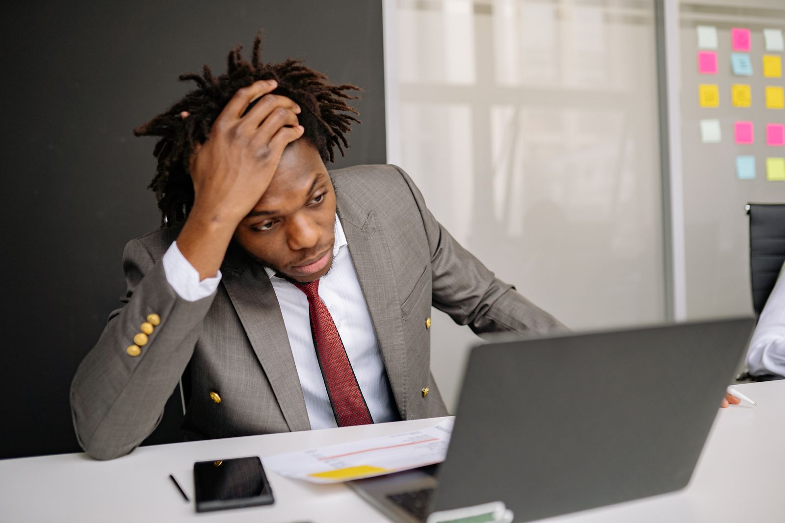 Professional kijkt bezorgd naar zijn laptop op kantoor, zoals bij AI-angst op de werkvloer