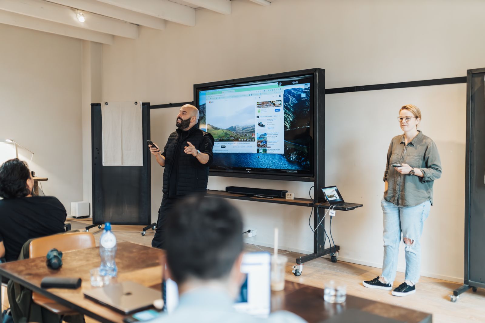 Leidinggevende presenteert voor het team met een scherm tijdens een AI-transitie op kantoor