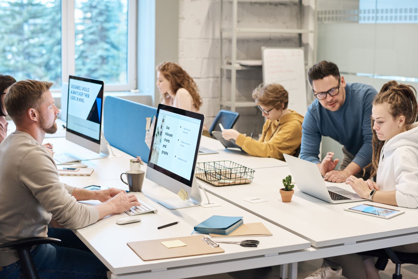 Divers team werkt samen achter computers op een moderne werkvloer tijdens AI-adoptie