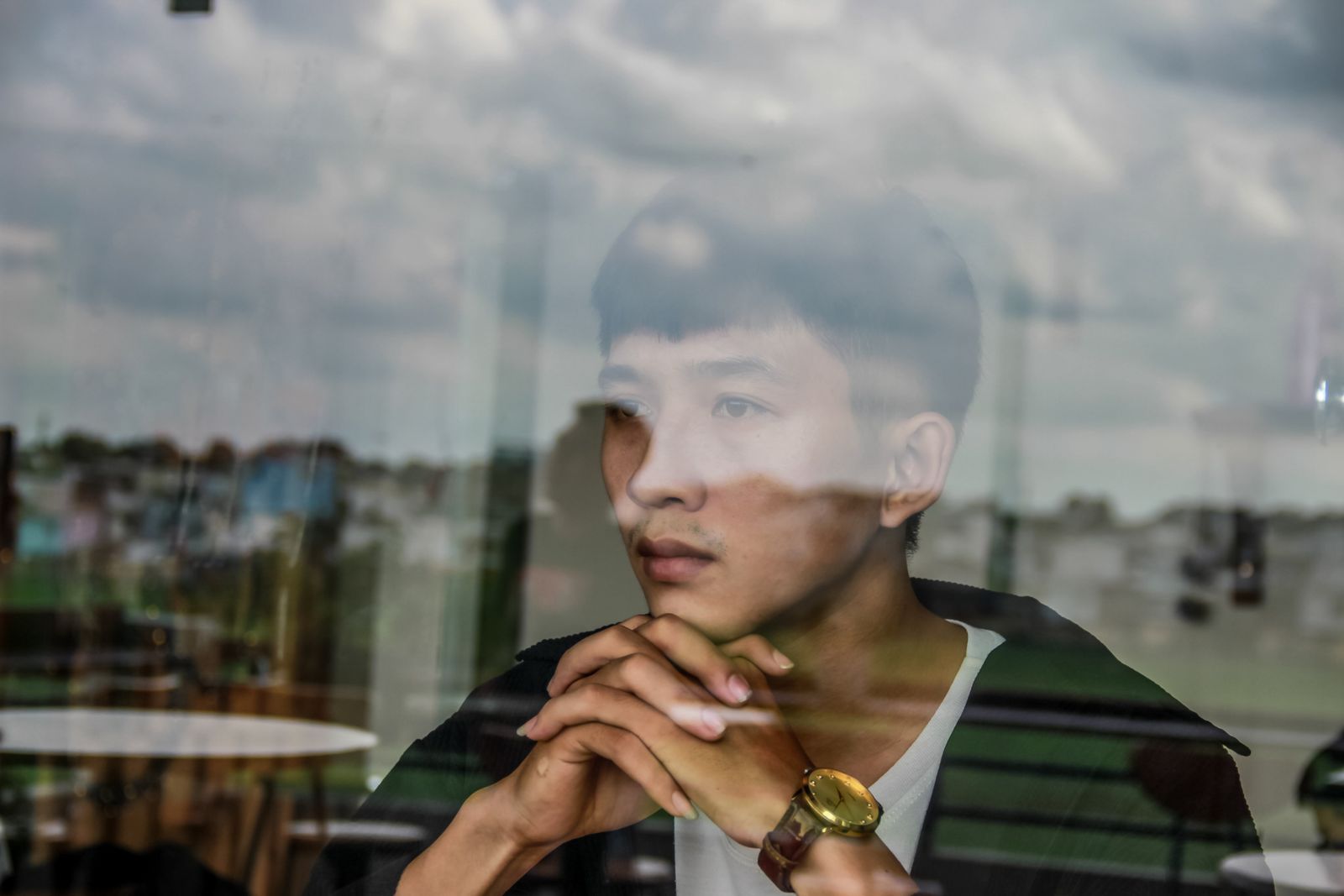 Jonge professional kijkt peinzend uit het raam en denkt na over zelfkennis en loopbaan