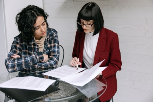Accountmanager en klant bespreken samen documenten aan een tafel op kantoor