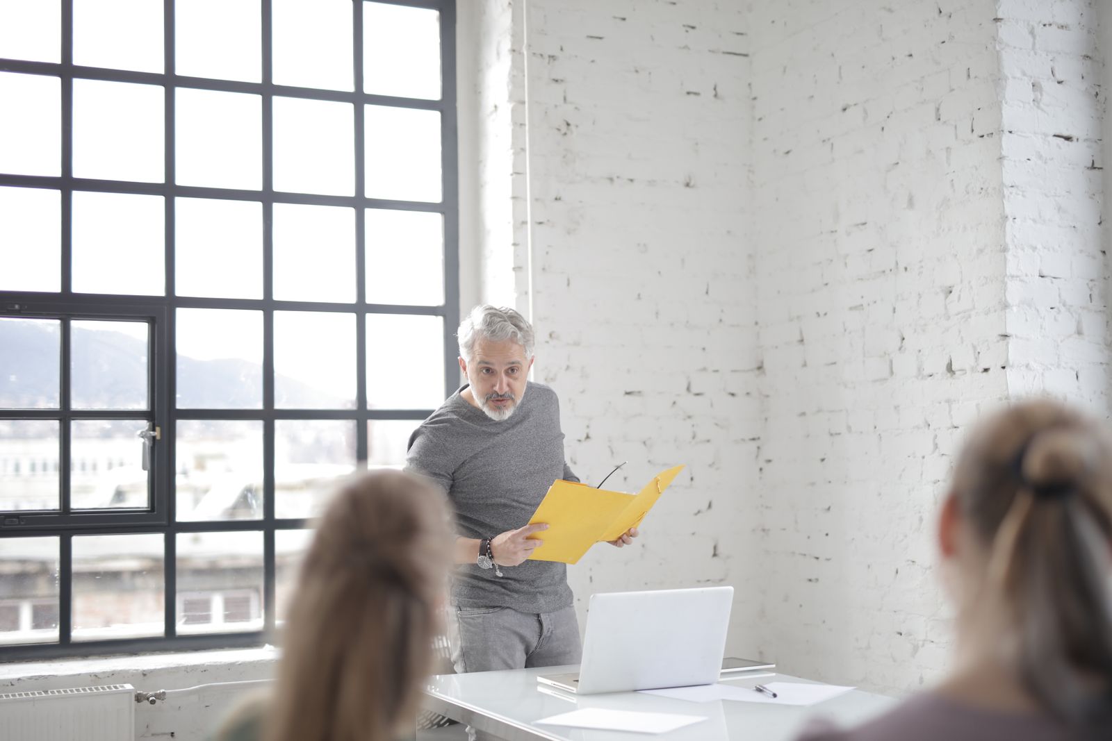 Leidinggevende licht plannen toe aan zijn team in een licht kantoor — DISC voor leidinggevenden
