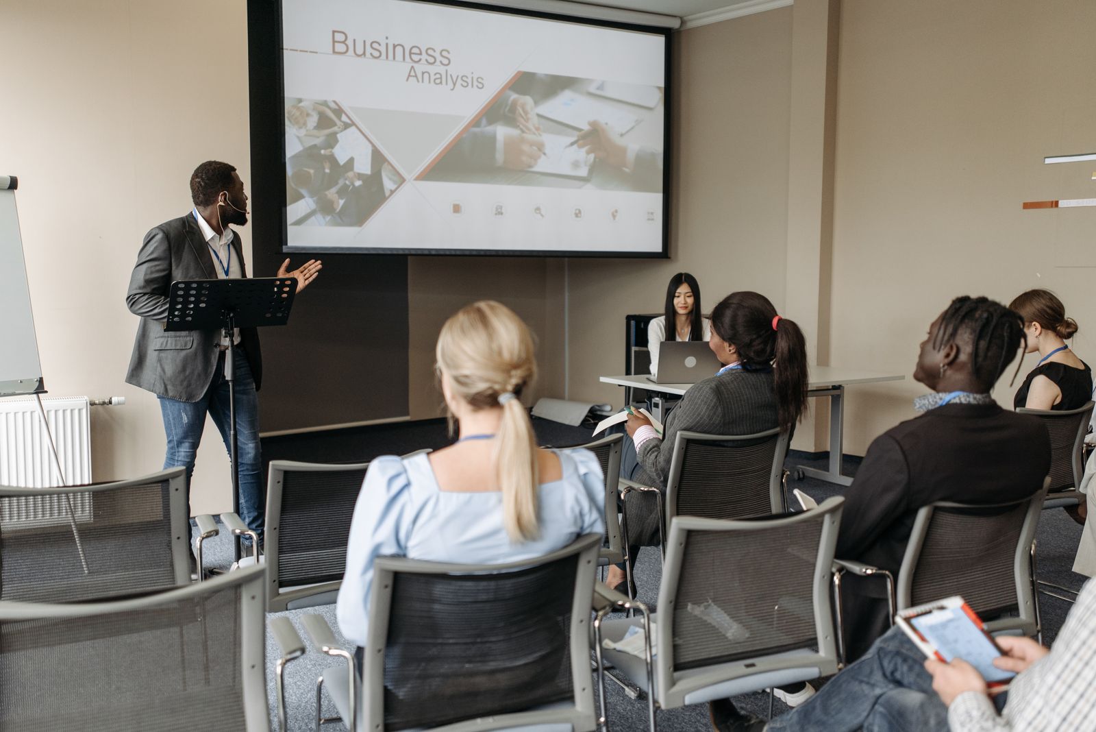 Diverse groep professionals bij een DISC-opleiding met presentator in een moderne trainingsruimte