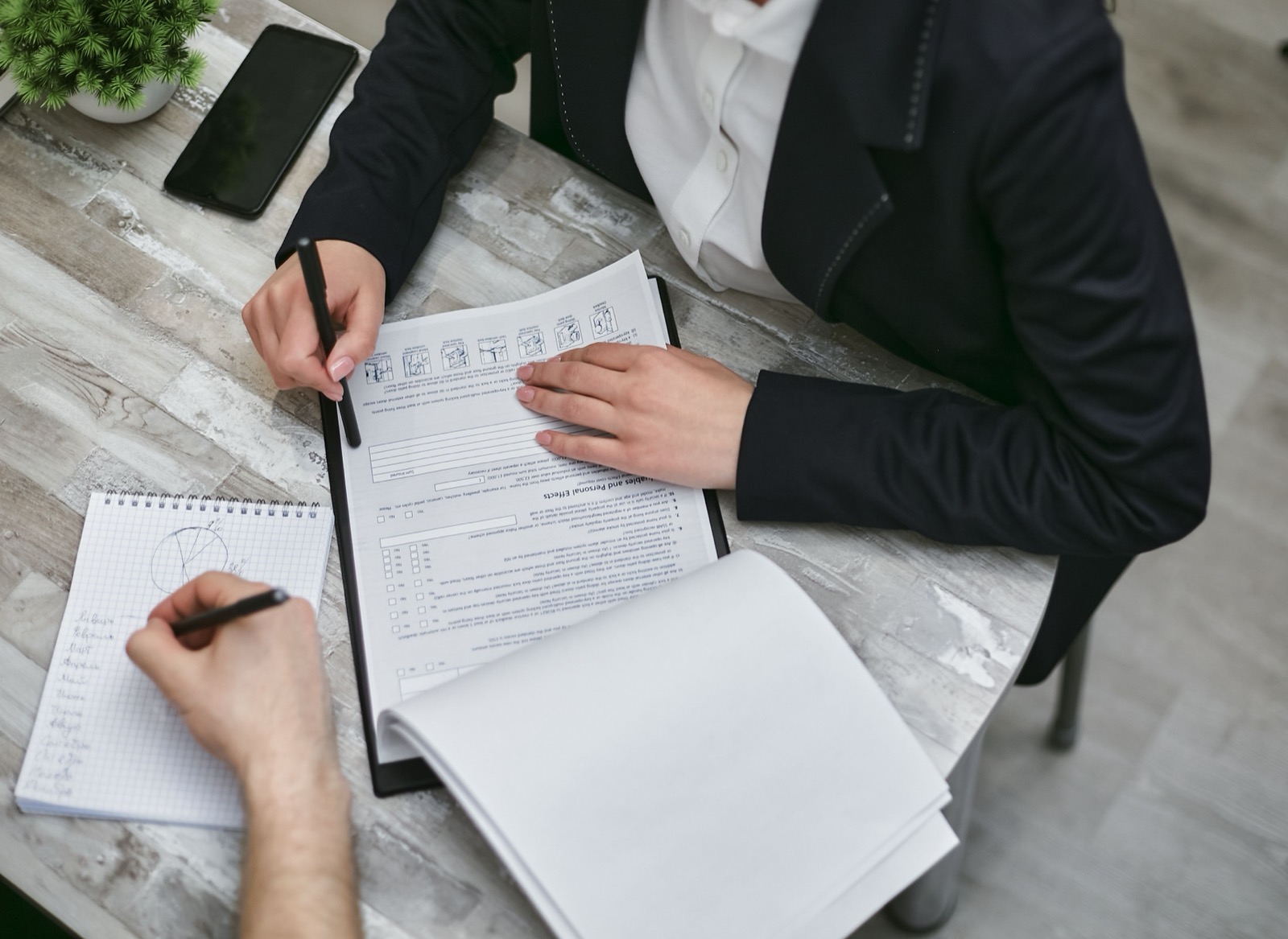 Twee professionals vergelijken documenten en aantekeningen: criteria voor het kiezen van een DISC-certificering