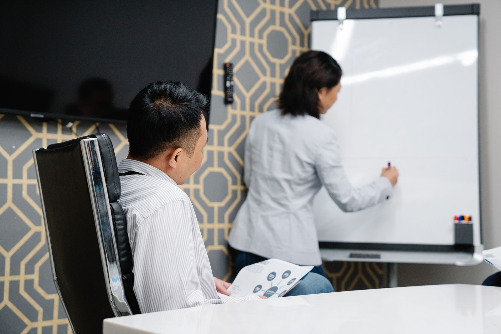 Professionals overleggen bij een whiteboard tijdens een training over gedragsstijlen