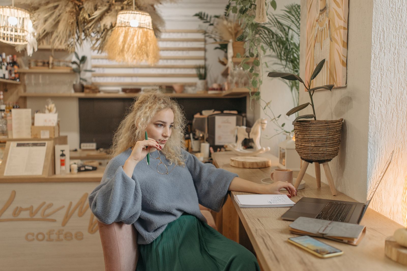 Coach werkt in een café aan laptop en notities voor haar positionering als DISC-coach