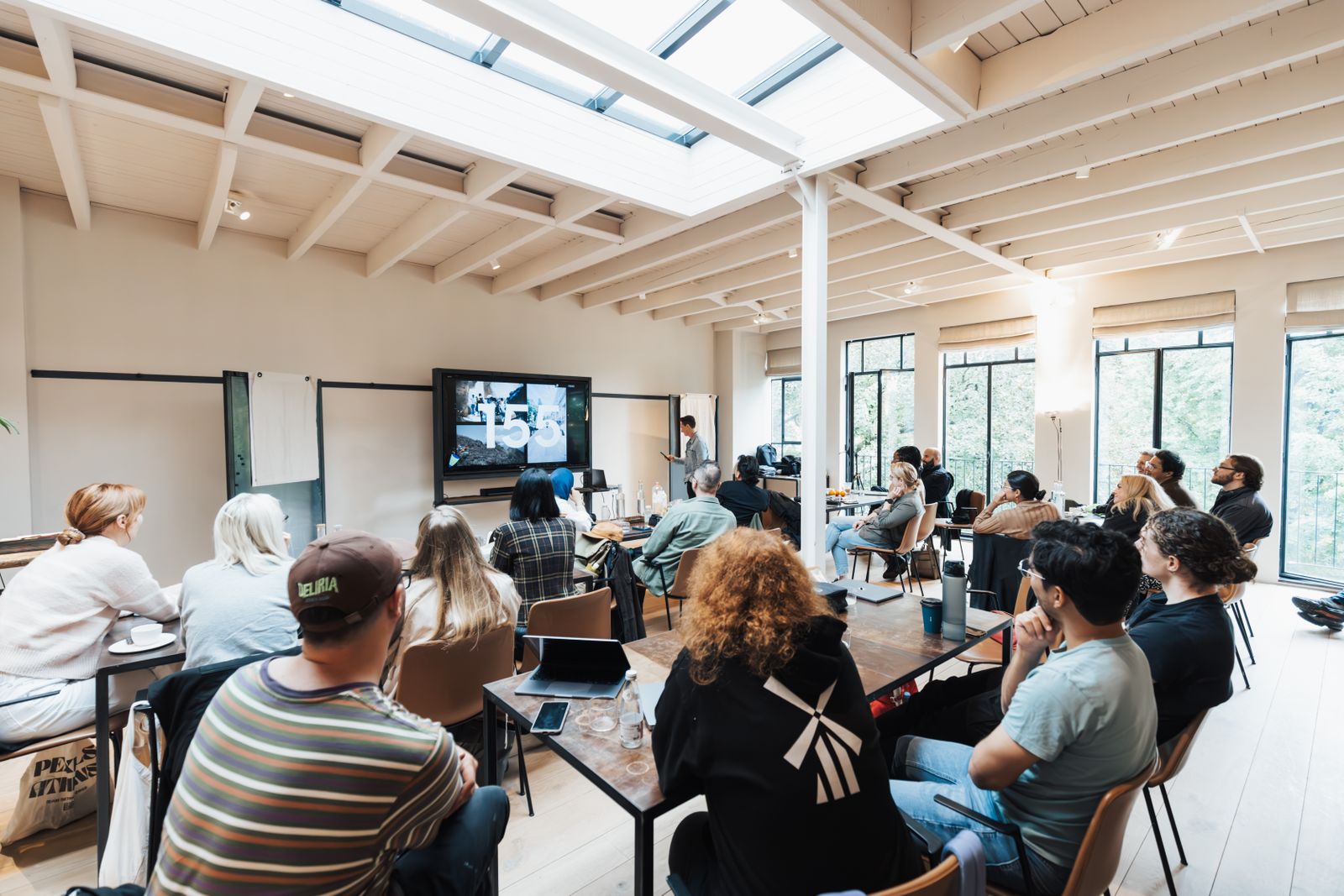 Groep professionals volgt een DISC-certificeringstraining in een lichte trainingsruimte
