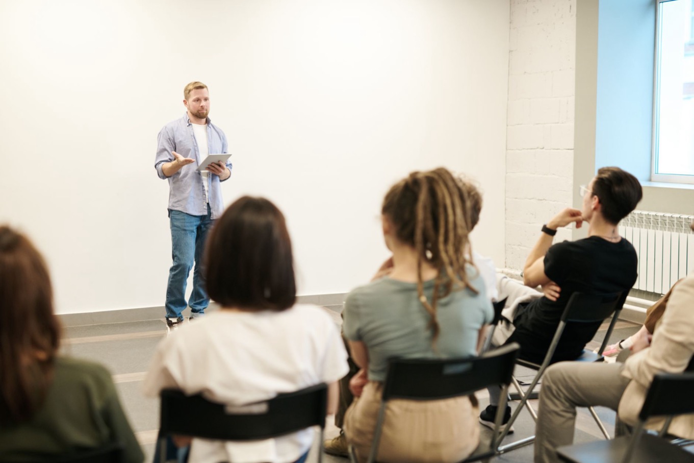 Trainer bespreekt DISC-materiaal met een groep deelnemers tijdens een DISC-certificering