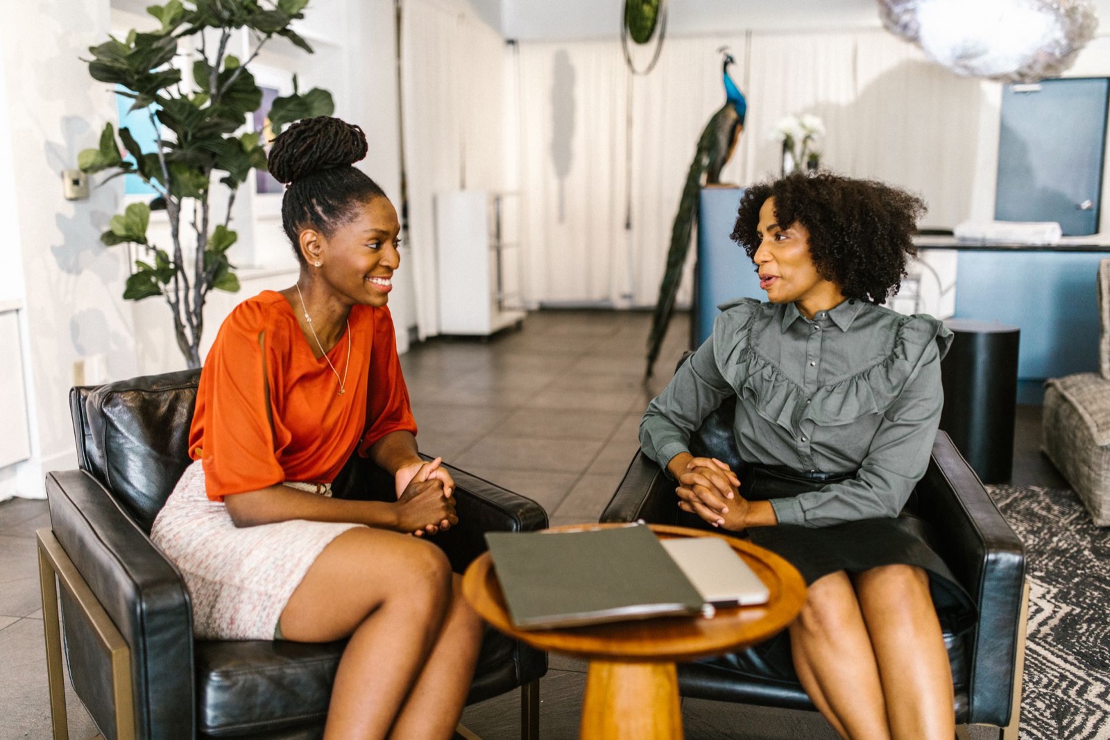Twee vrouwen in gesprek tijdens een coachgesprek, waarin de coach vragen stelt die passen bij de DISC-stijl