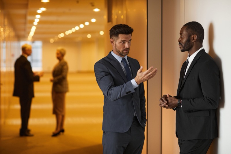 Twee collega's in gesprek in een kantoor, symbool voor een moeilijk gesprek voeren op de werkvloer