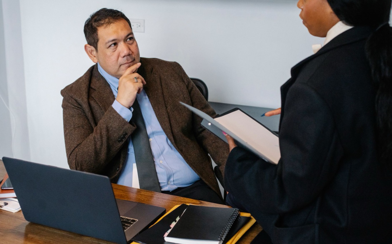 Medewerker legt een stuk voor aan een leidinggevende aan een bureau, een moment van managing up