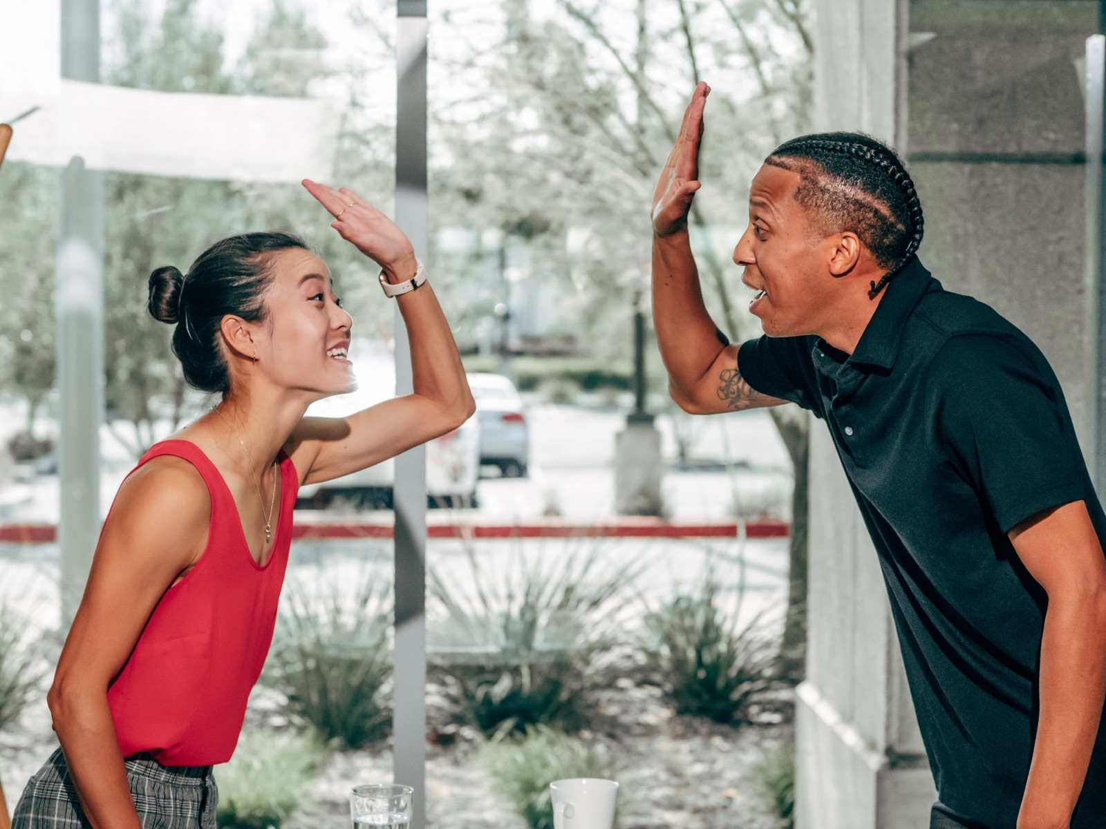 Twee collega's geven elkaar een high five op kantoor als teken van waardering