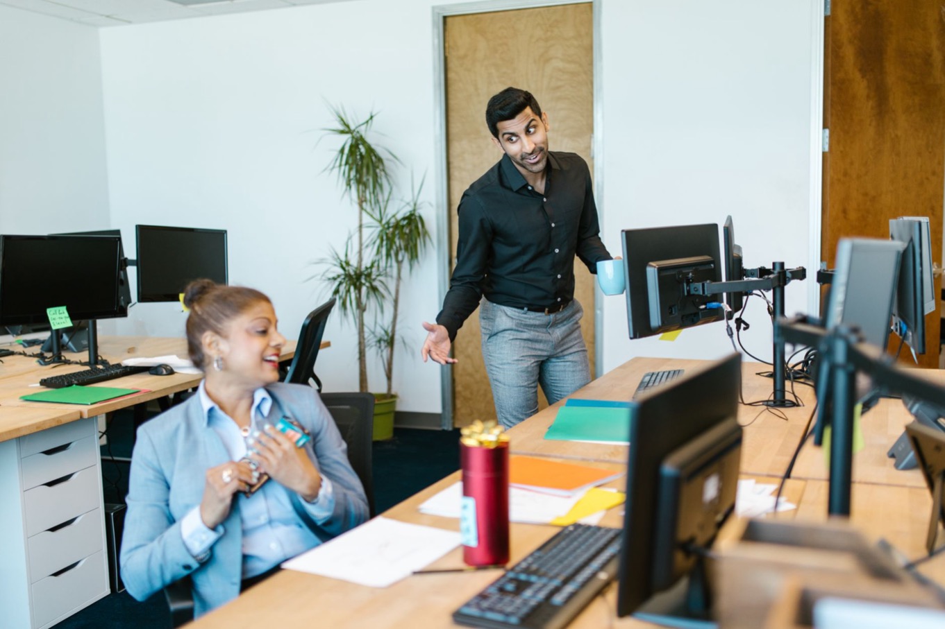 Twee collega's in gesprek op een modern kantoor, passend bij DISC in werving en onboarding