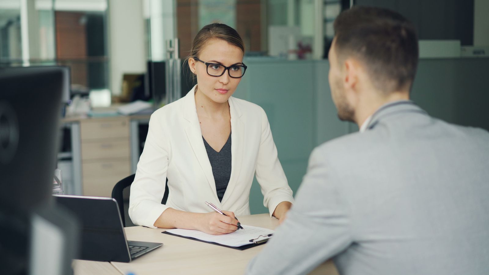 Sollicitatiegesprek tussen twee professionals in een modern kantoor