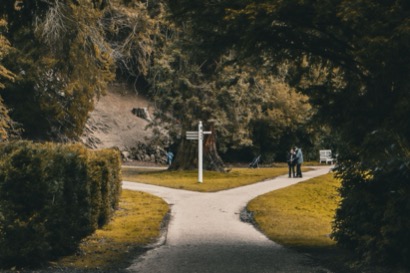 Pad in een park dat op een splitsing uitkomt bij een wegwijzer, symbool voor hoe dezelfde DISC-stijl bij een andere drijfveer een andere richting op gaat