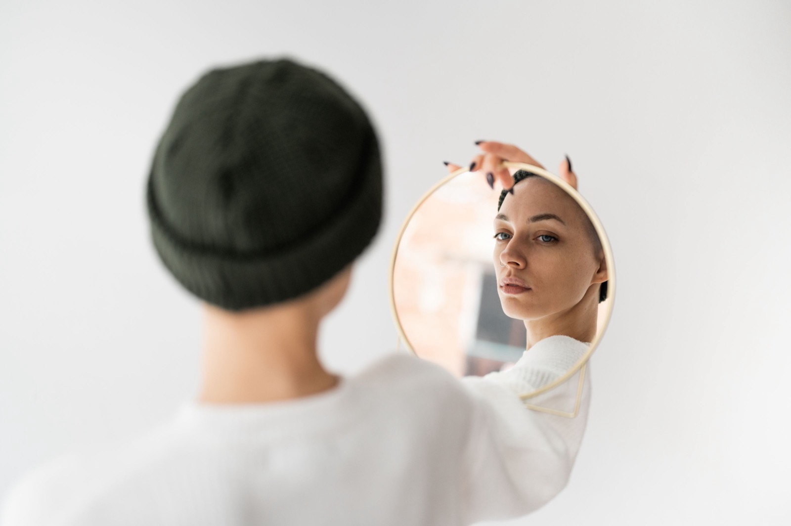 Vrouw kijkt naar haar eigen spiegelbeeld, symbool voor zelfherkenning in een persoonlijkheidsprofiel