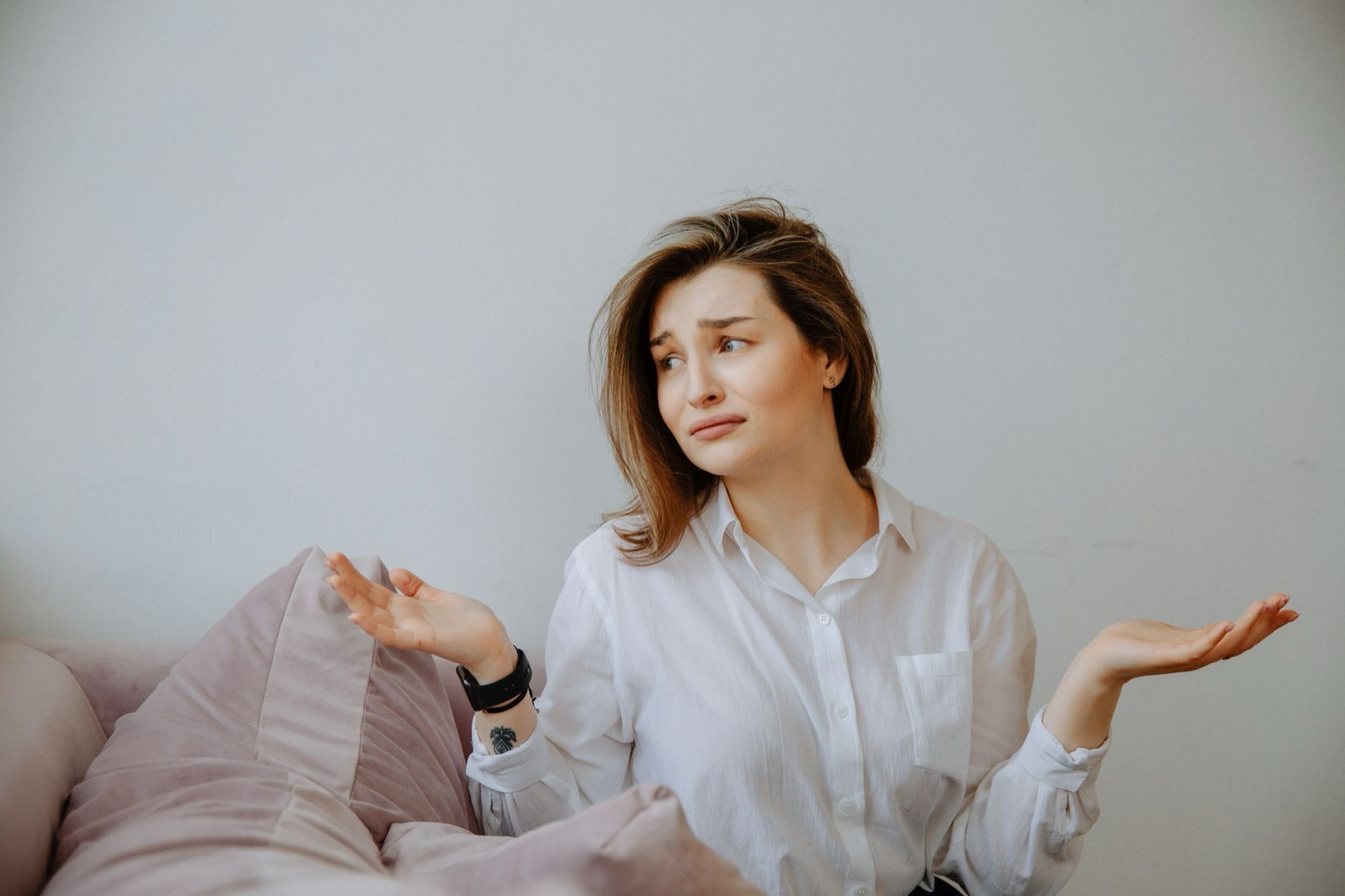 Vrouw haalt met opgeheven handen haar schouders op tijdens een gesprek, beeld bij DISC als excuus voor gedrag
