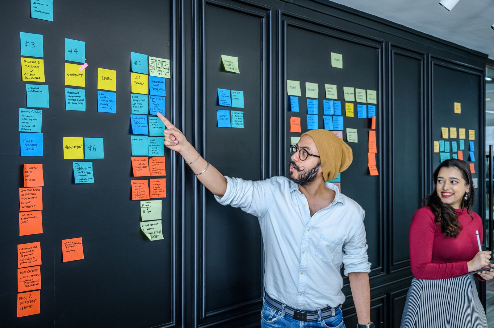 Team bespreekt samenwerking met kleurrijke memoblaadjes op een bord, zoals bij een DISC-teamsessie