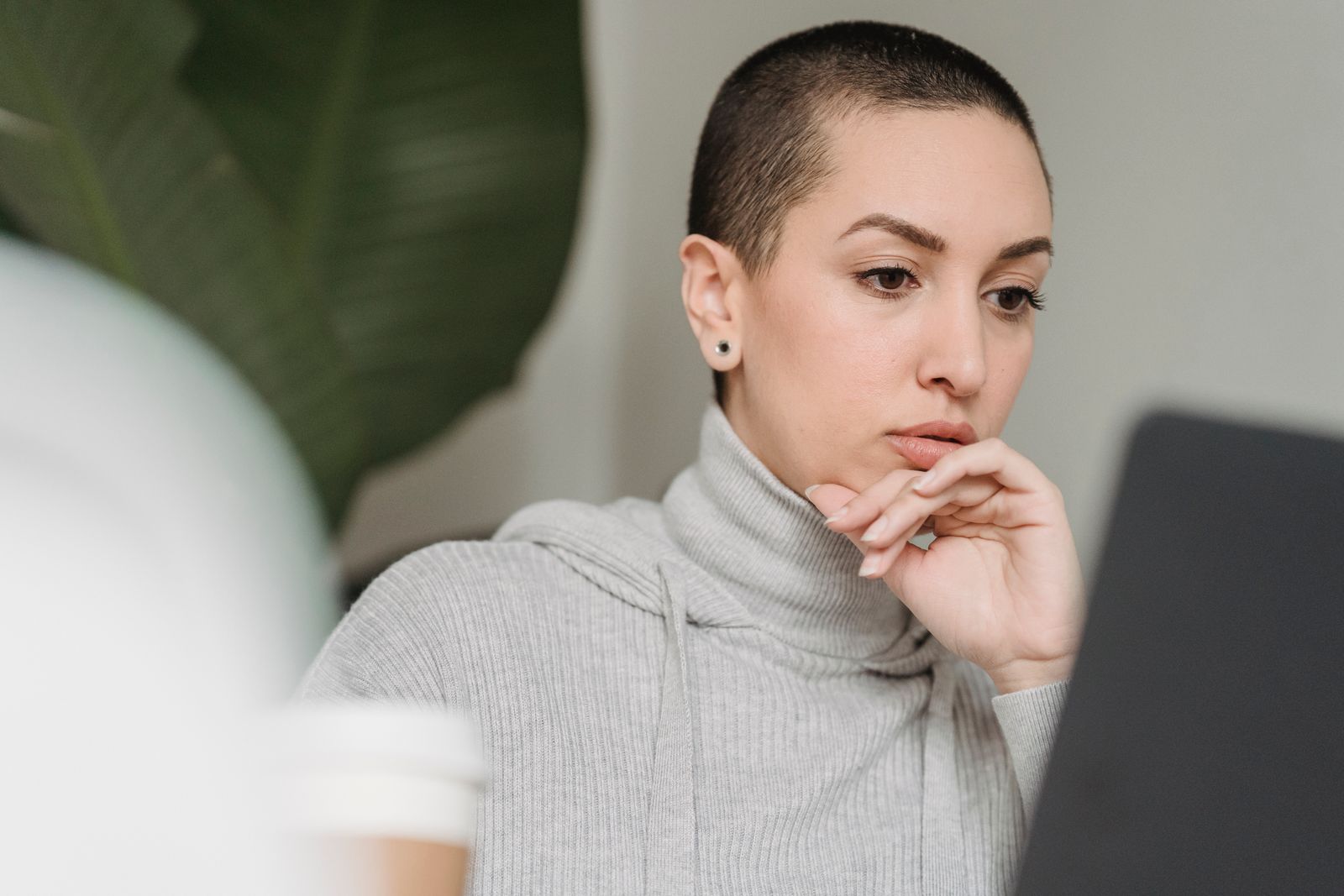 Vrouw kijkt nadenkend en kritisch naar een online test op haar laptopscherm