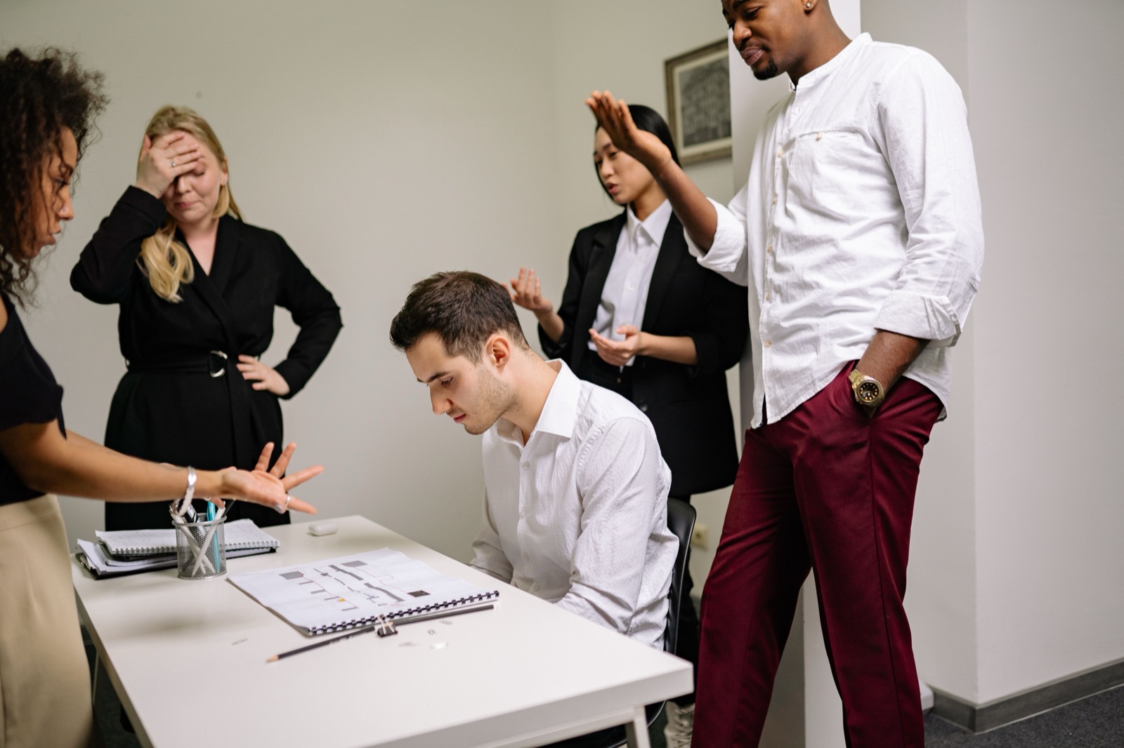 Collega's in een gespannen discussie tijdens een vergadering op kantoor, waarbij één collega zijn zin doordrukt