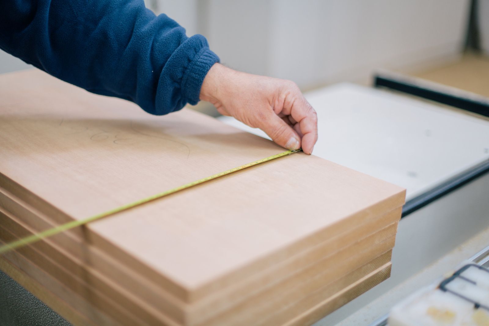 Close-up van een hand die met een rolmaat een plank precies opmeet, beeld bij de doorgeslagen sterke punten van de C-stijl