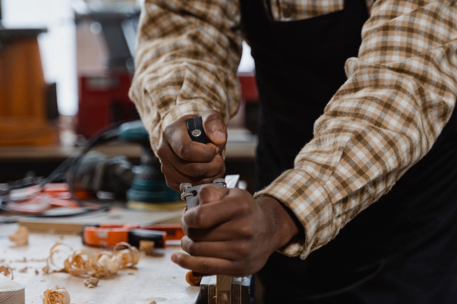 Vakman schaaft hout in een werkplaats, als beeld bij het zelf vormgeven van je baan met jobcrafting