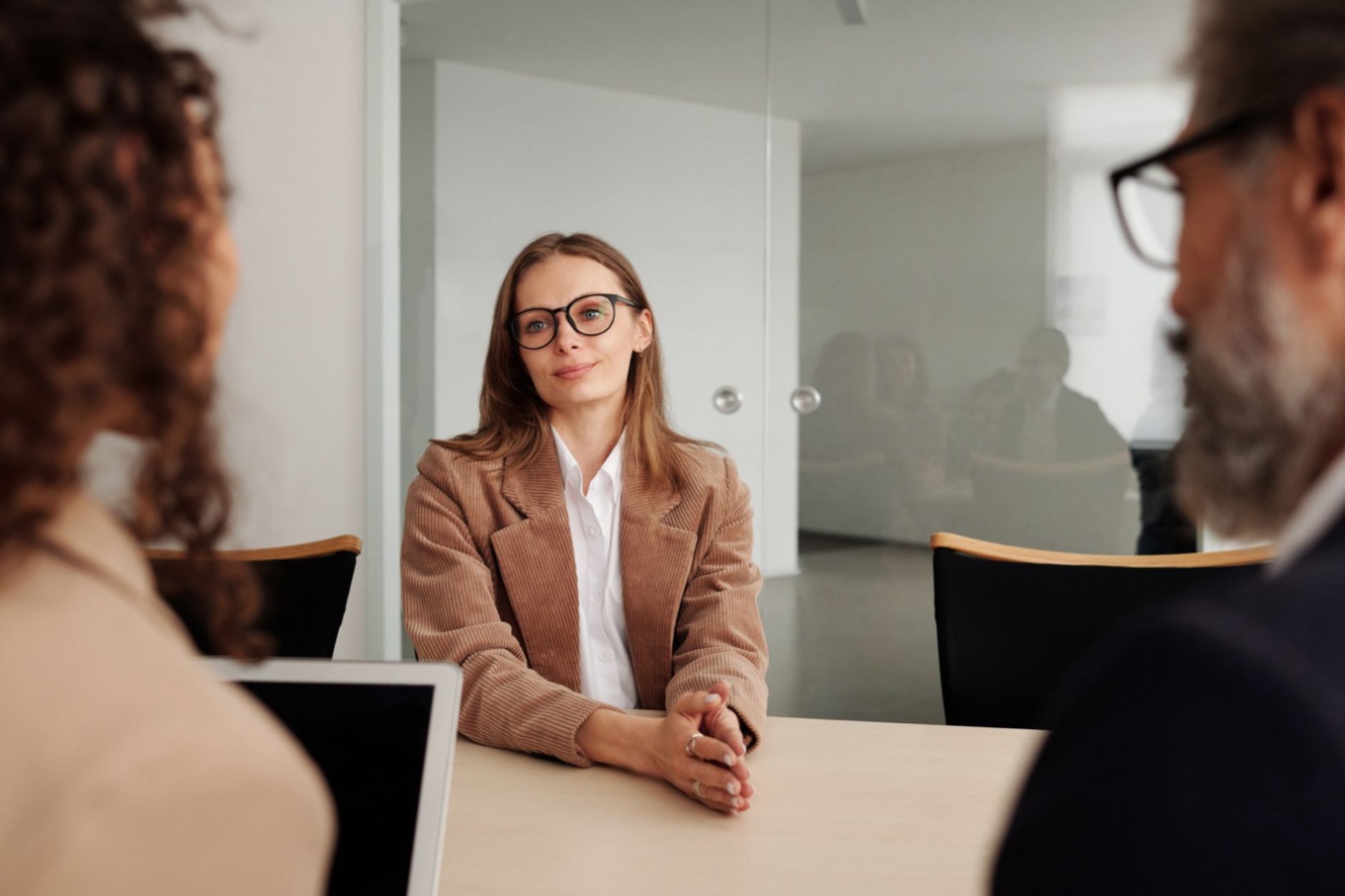 Sollicitant in een sollicitatiegesprek luistert aandachtig naar twee interviewers aan tafel
