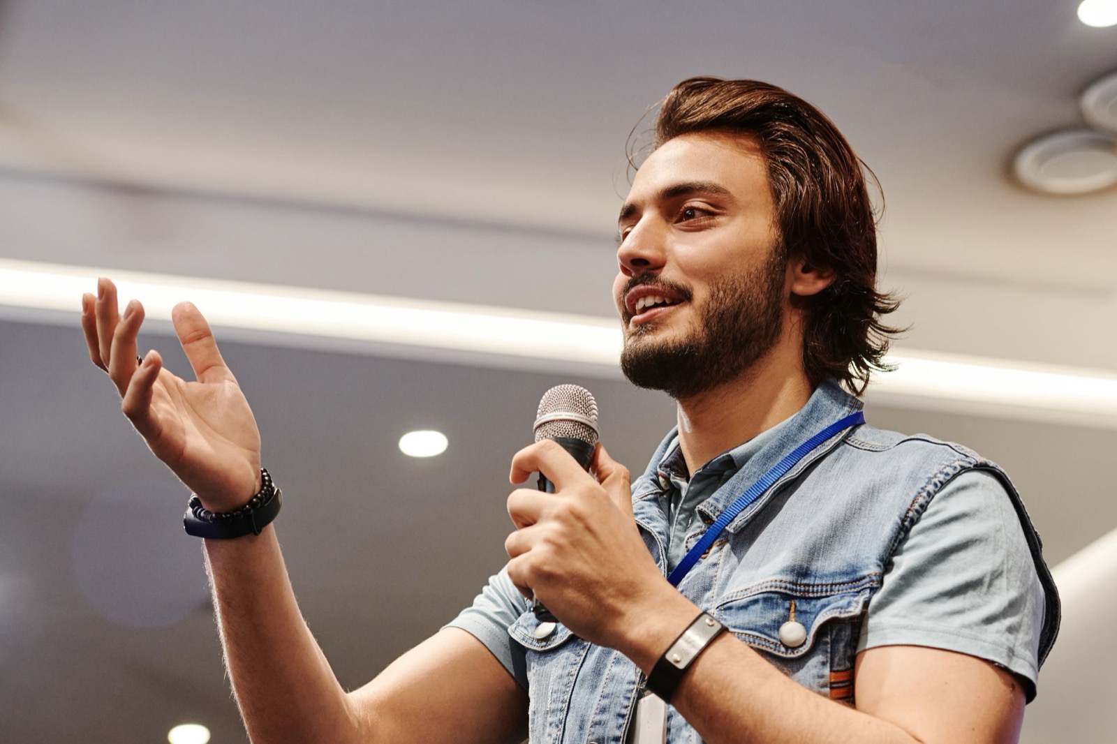 Spreker met microfoon presenteert enthousiast voor publiek, zoals de Presenter-wielpositie (hoog I) in het DISC-wiel