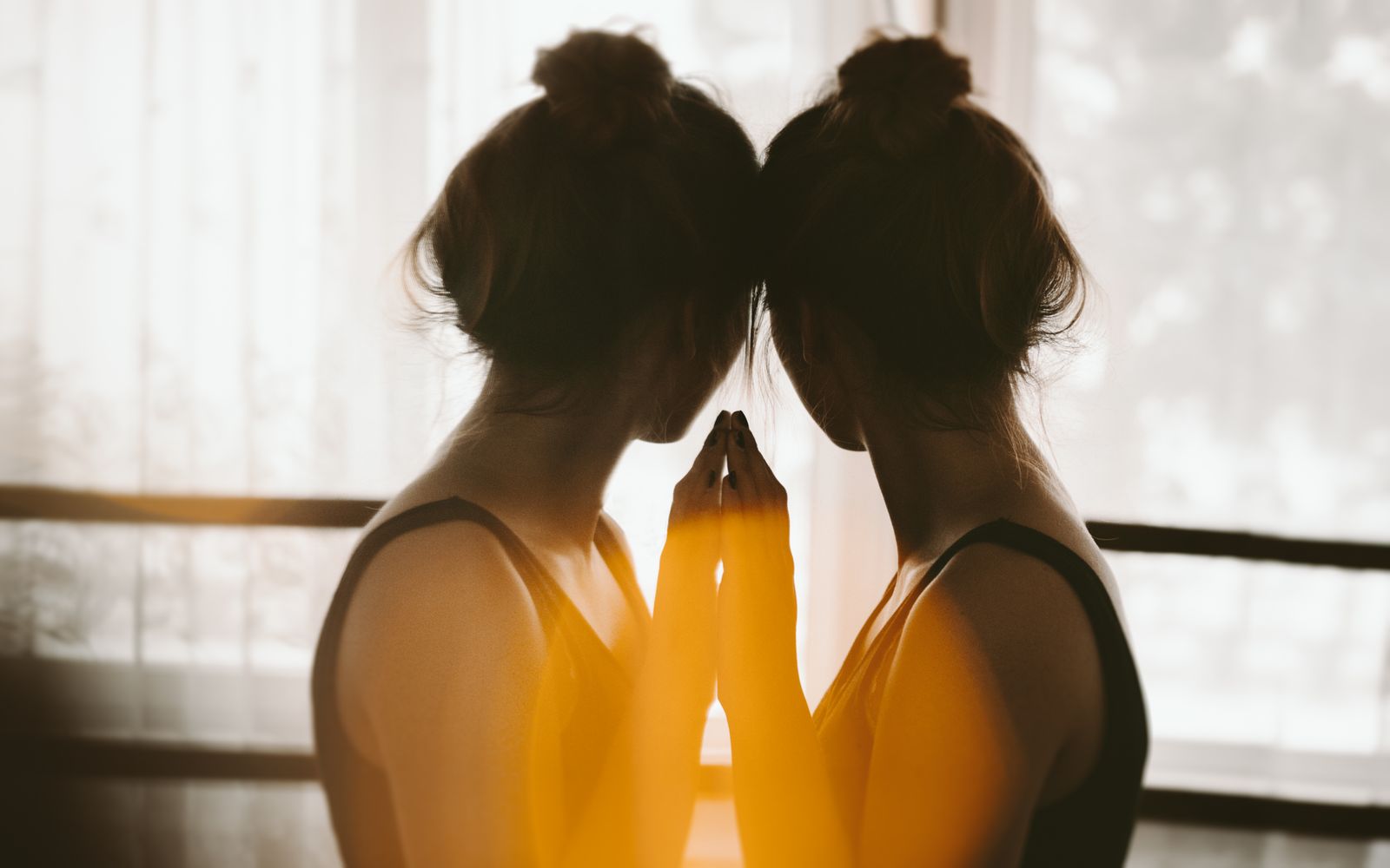 Vrouw kijkt in de spiegel naar zichzelf, beeld voor het me-me-conflict tussen basisstijl en responsstijl