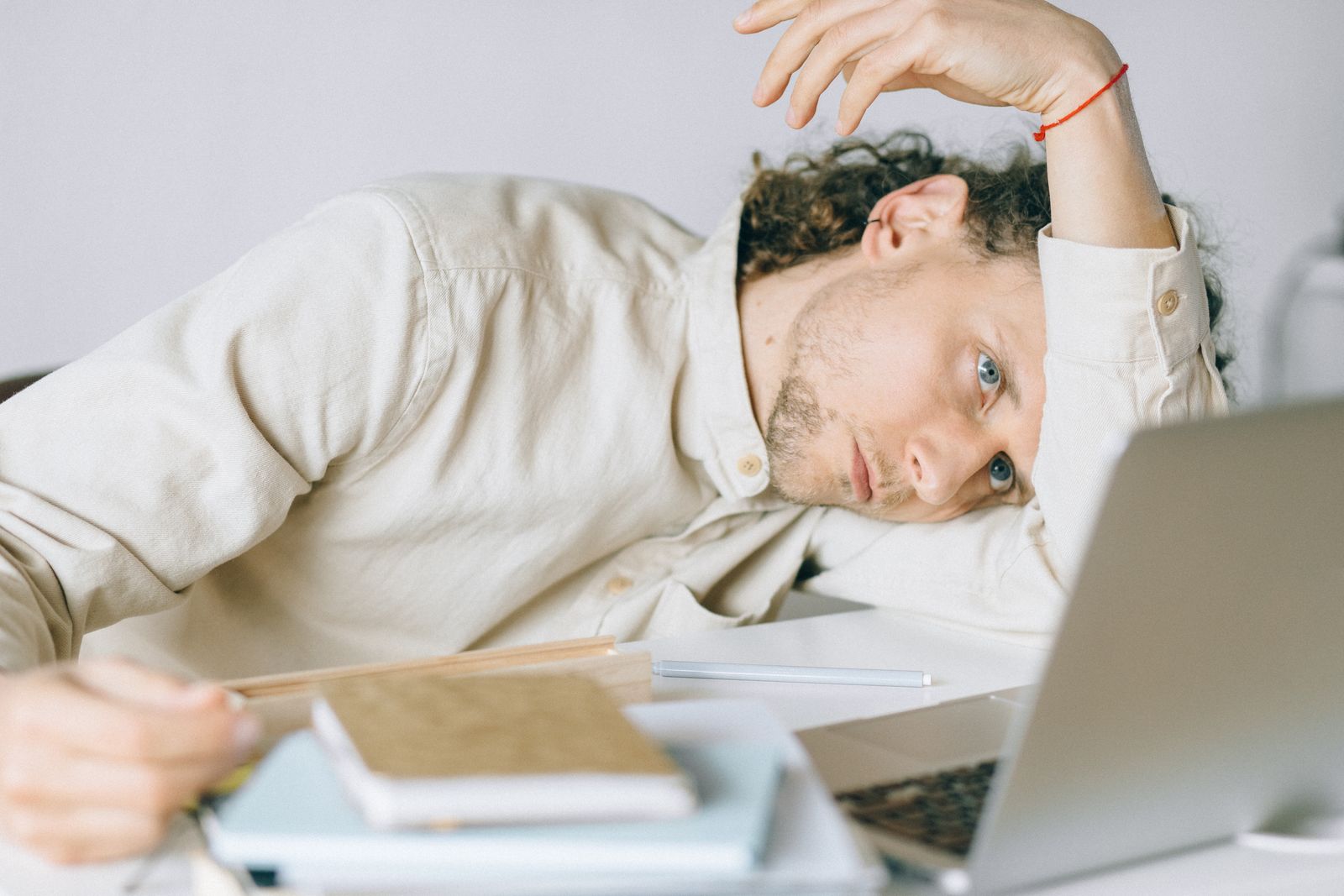 Vermoeide man aan zijn bureau met stress, als beeld bij een overshift-profiel en burn-outrisico