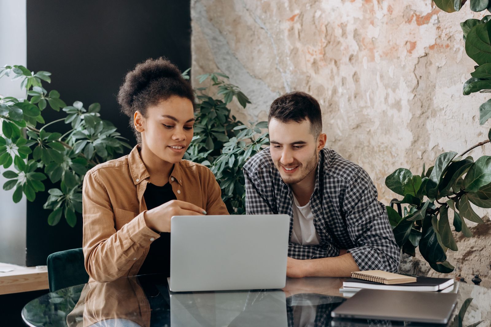 Twee collega's met verschillende DISC-stijlen werken samen achter één laptop