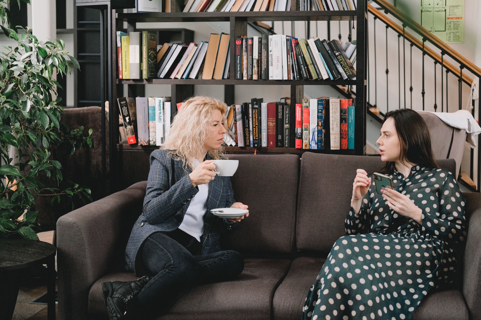 Twee collega's in gesprek tijdens een rustige werkpauze: de een vertelt enthousiast, de ander luistert aandachtig, zoals bij een samenwerking tussen een I-stijl en een S-stijl