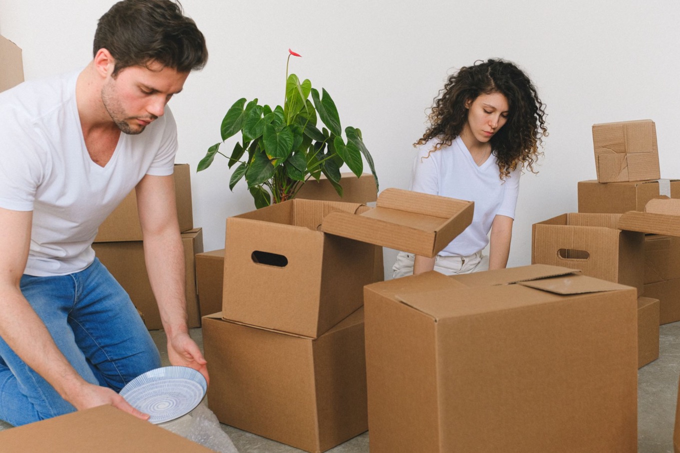 Man en vrouw pakken samen breekbare spullen in verhuisdozen, DISC-combinaties bij een verhuizing