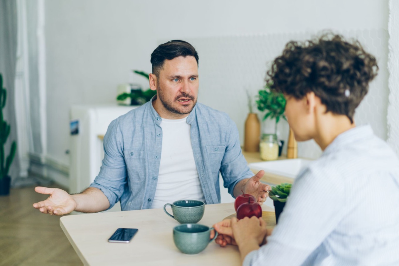 Twee mensen in een rustig gesprek met koffie aan tafel: omgaan met een S-stijl