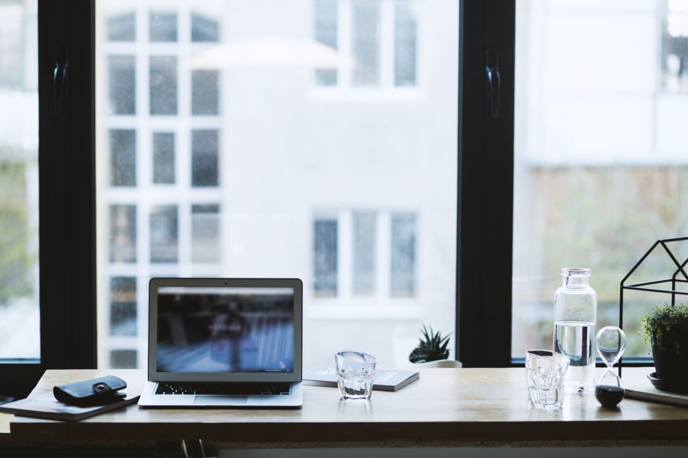 Opgeruimd thuiswerkbureau met laptop bij een raam, werkplek voor thuiswerken met een D-stijl
