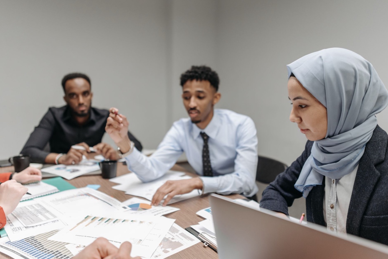 Divers team in overleg aan een vergadertafel met verschillende gedragsstijlen