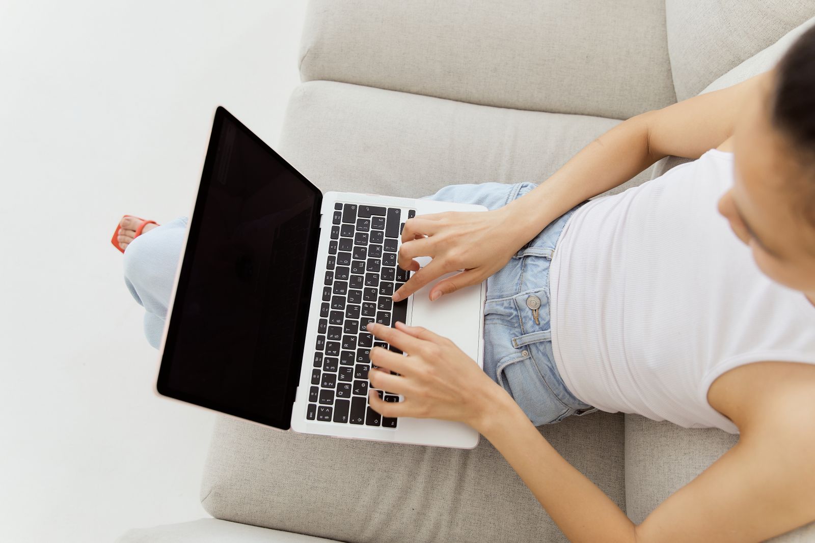 Vrouw doet op de bank een online DISC-test op haar laptop, als beeld bij gratis test versus You.Manual-rapport