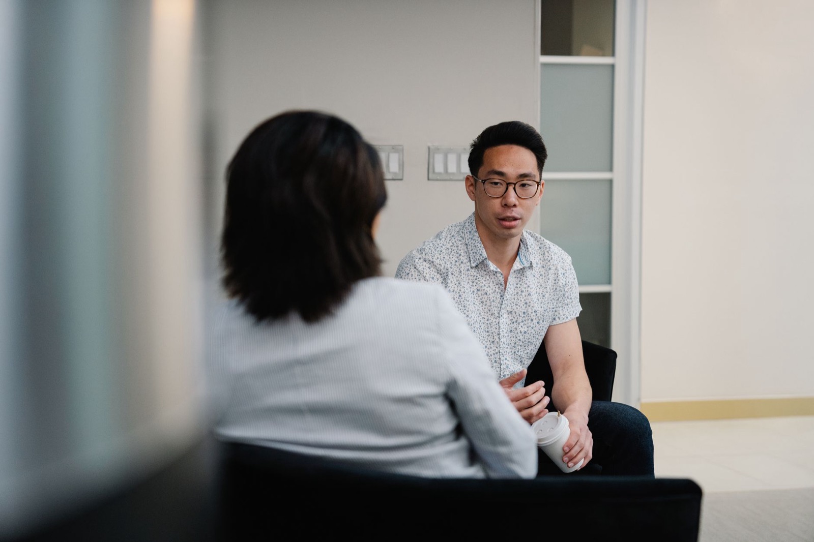Twee collega's in gesprek op kantoor: de een vertelt, de ander luistert door zijn eigen filter